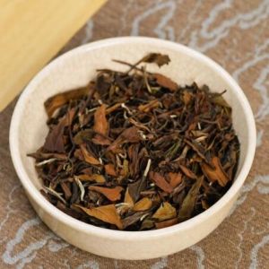 loose leaf of aged shou mei white tea in a tea cup